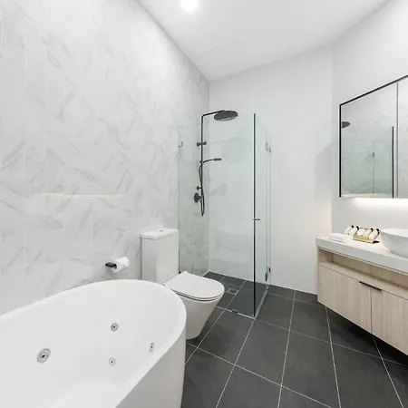Meriton Suites Bondi Junction Sydney Exterior photo The photo shows a modern bathroom featuring several key elements. On the left, there is a freestanding bathtub with a sleek design. In the center, a glass shower enclosure is visible, complete with a showerhead on the wall. Adjacent to the shower, th