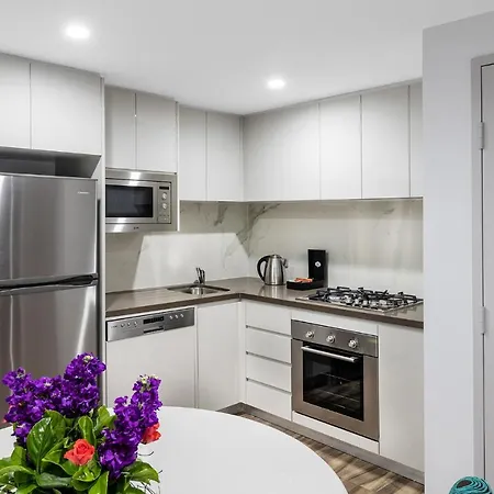Meriton Suites Bondi Junction Sydney Exterior photo The photo shows a modern kitchen with a clean and contemporary design. 

- **Appliances**: It features stainless steel appliances, including a refrigerator, microwave, and an oven with a gas cooktop.
- **Cabinets**: The upper cabinets are white, prov